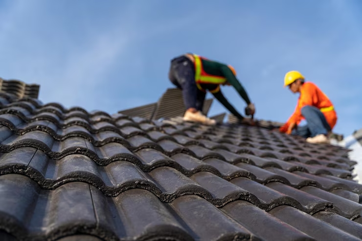 2-couvreurs-travaillant-travail-hauteur-pour-installer-tuiles-beton-nouveau-toit-construction-nouvea
